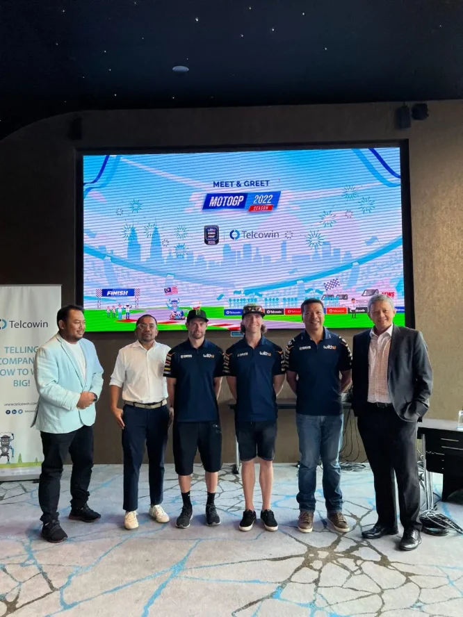 Guests and the riders in front of the Meet & Greet backdrop